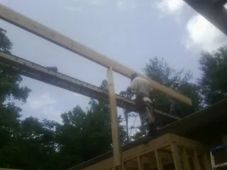 Carpenter setting a ridge beam over a new addition frame — Ice Dam Removal by Roofing Brothers in Earleville