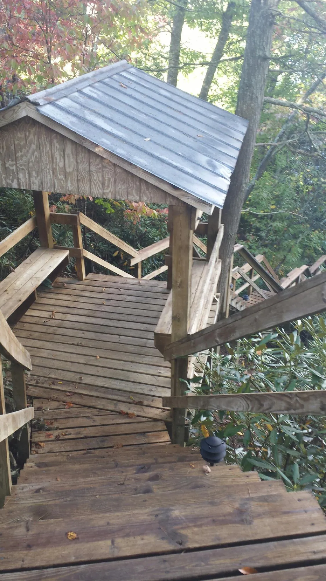 Metal roofed shelter over wooden steps on a wooded walkway — Skylight Repair & Installation work by our crew in Earleville