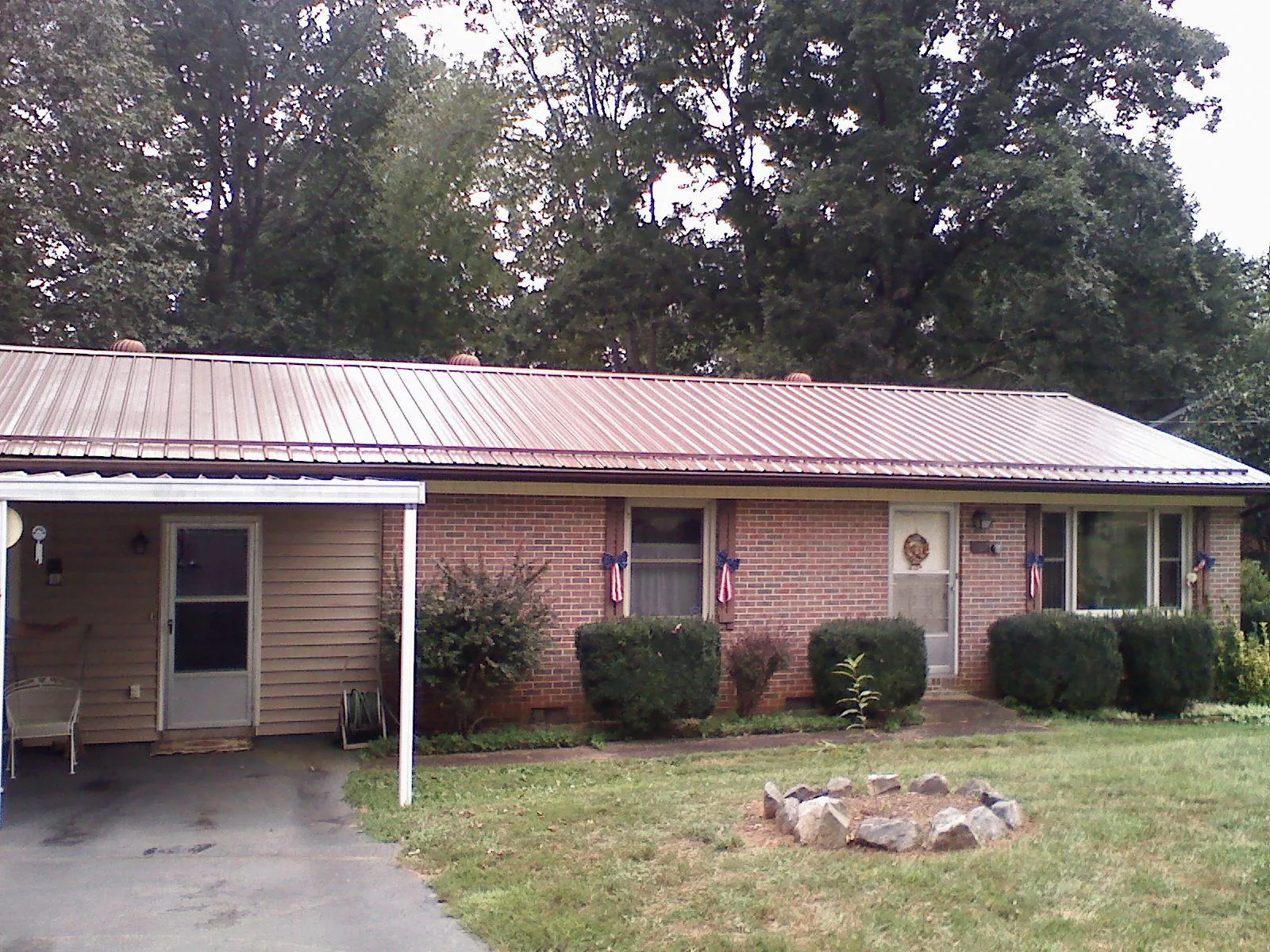 Bronze metal roof and carport on a brick ranch home — Roof Repair work by our crew in Earleville